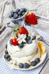 Meringue decorated with blueberries, strawberries and orange