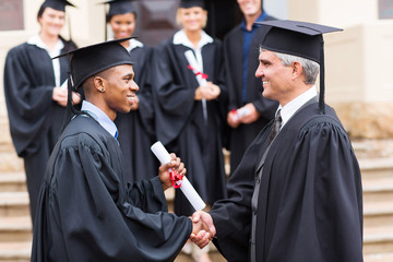 african male graduate handshaking with dean