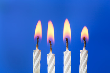 Burning white candles over blue background