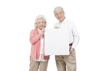 .Senior couple holding white board.