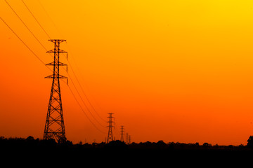 High voltage power pole middle of a cornfield with orange sky