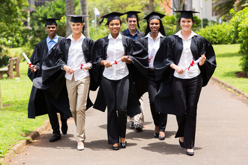 group of multiracial graduates walking on campus