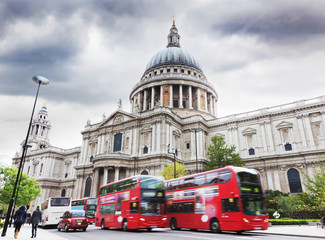 Fototapeta na wymiar St Paul's Cathedral in London, the UK. Red buses, cloudy sky