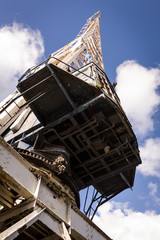 Old crane in docks with blue sky background.