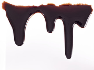 Melted chocolate dripping on white background