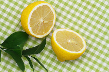 Lemon halves on green checkered cloth with copy space