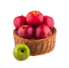 Red and green apples in a wooden basket, on white background.