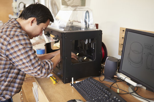 Male Architect Using 3D Printer In Office