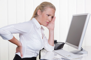 Frau mit Rückenschmerzen im Büro