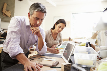 Two Architects Making Models In Office Using Digital Tablet