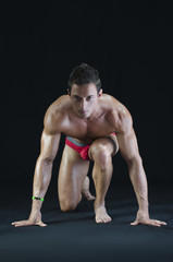 Handsome young muscular man ready to sprint and run