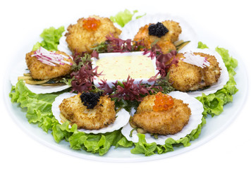 fried scallops decorated with caviar and greens