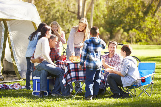 Two Families Enjoying Camping Holiday In Countryside