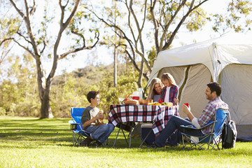 Family Enjoying Camping Holiday In Countryside - obrazy, fototapety, plakaty