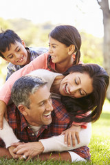 Family Lying On Grass In Countryside