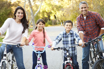 Portrait Of Hispanic Family On Cycle Ride In Countryside