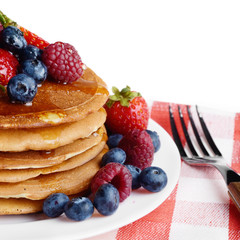 Pancakes with berries and honey over white