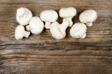 Top view of agaricus mushroom on wooden table. Copy space