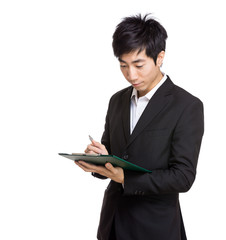 Asia businessman writing on file pad