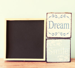Fototapeta premium blackboard and wooden boxes over wooden table 