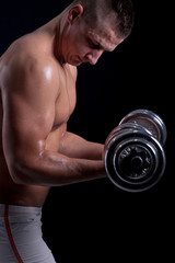 Fototapeta na wymiar Fit muscular man exercising with dumbbell