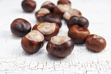 Brown chestnuts on wooden background