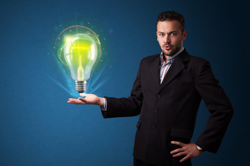 Fototapeta na wymiar Glowing lightbulb in the hand of a businessman