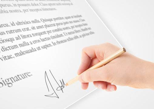 Hand writing personal signature on a paper form