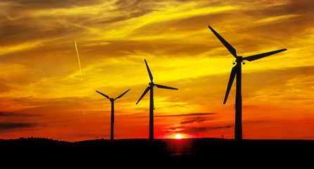 Obraz premium Silhouette of wind power station at sunset.