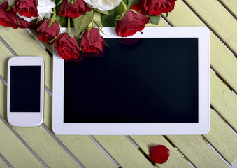 red roses with a tablet