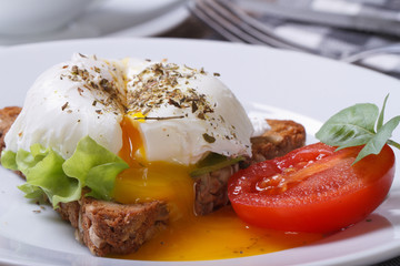 Obrazy na Szkle  kanapka z sałatką, jajko w koszulce otwarte na białym talerzu