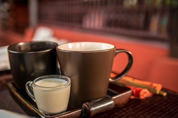 cup of tea with milk at the wooden table