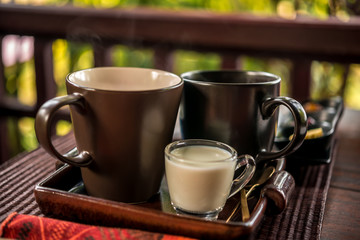 cup of tea with milk at the wooden table