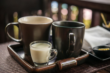 cup of tea with milk at the wooden table