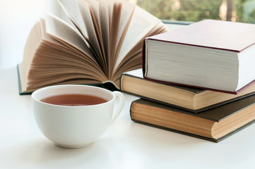 Cup of black tea and some books to read lying on the table