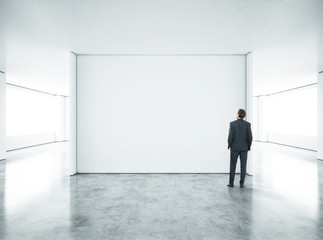 Businessman standing in bright office