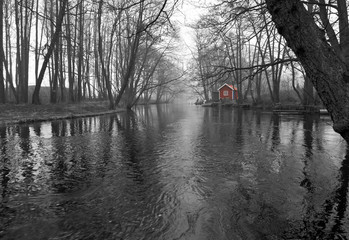 Monochromatic landscape of spring river with red house