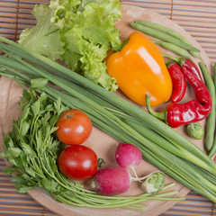 fresh vegetables on a round board and bamboo mat