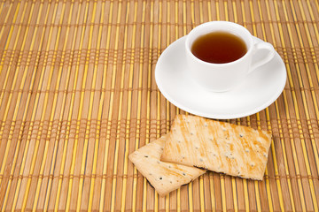 cookies and cup of tea on bamboo mat