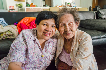 Asian elder mother and daughter hold together in home scenery