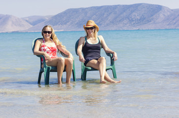 Two Happy Woman relaxing at the beach together
