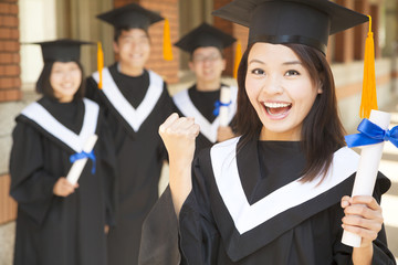 young college graduate holding diploma  and make a fist