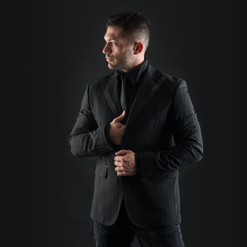 Confident man close up portrait against black background.