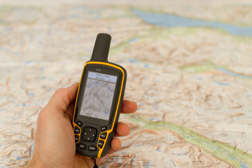 Hand held outdoor GPS and a map.