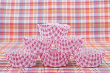 Paper molds for baking muffins on the table.