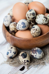 Close-up of raw chicken and quail eggs, vertical shot