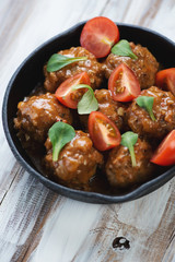 Meatballs with corn salad leaves and cherry tomatoes
