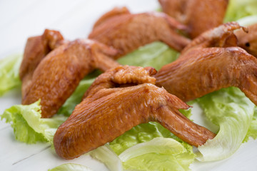Close-up of smoked chicken wings on fresh salad leaves