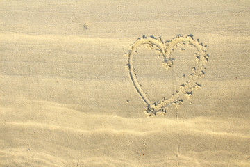 Heart shape drawn on white beach sand