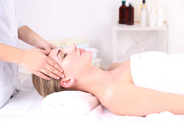 Obraz na płótnie Canvas Beautiful young woman having head massage in spa salon